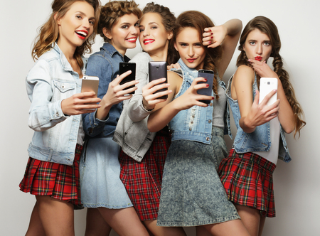 lifestyle, technology and internet concept:group of young women looking at their smartphones