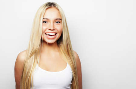 Young cute smiling blond girl, over white backgroundの写真素材