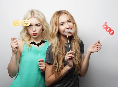 two stylish hipster girls best friends ready for party, over gray backgroundの写真素材