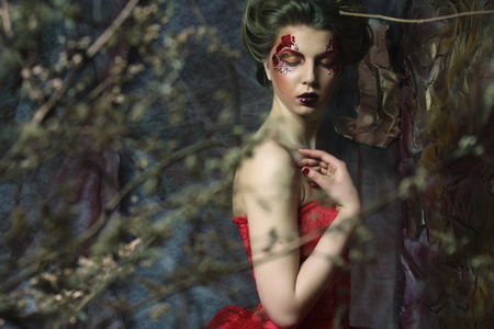 Fashion portrait of romantic beautiful girl with hairstyle, red lips, art dress.Princess in mistery house. Creative concept Once upon a time in fantasy.の写真素材