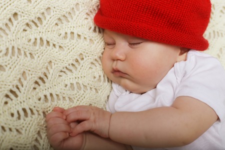 Peaceful baby lying on a bed while sleepingの写真素材