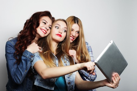 life style, tehnology and people concept: hipster girls friends taking selfie with digital tabletの写真素材