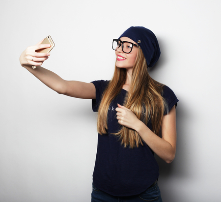 life style, happiness, emotional and people concept: Pretty hipster girl taking selfie.の写真素材
