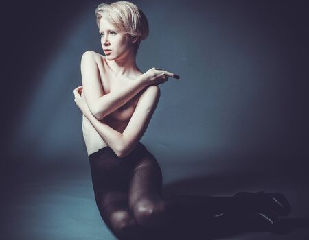 seductive woman sitting in fashion pose wearing black pantyhoseの写真素材