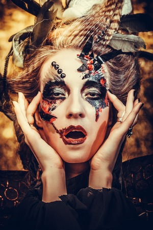 Young  woman wearing dark costume. Bright make up and smoke-  halloween theme.の写真素材