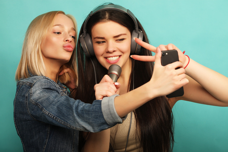 lifestyle, emotion  and people concept: Happy girls  with micropの写真素材