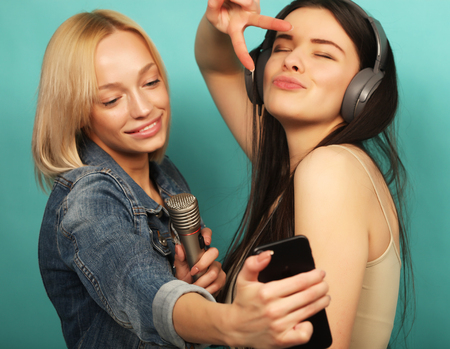 lifestyle, emotion  and people concept: Happy girls  with micropの写真素材