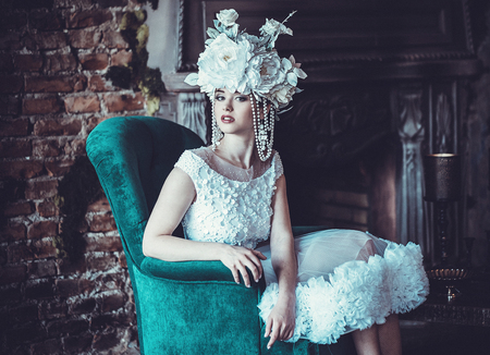 Beautiful bride sits on a chair. Luxury palace.の写真素材
