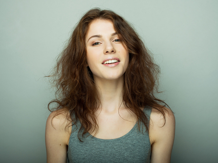 lifestyle and people concept: Young casual woman portrait. Clean face, curly hair.の写真素材