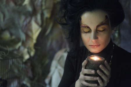 Portrait of beautiful young woman with candle