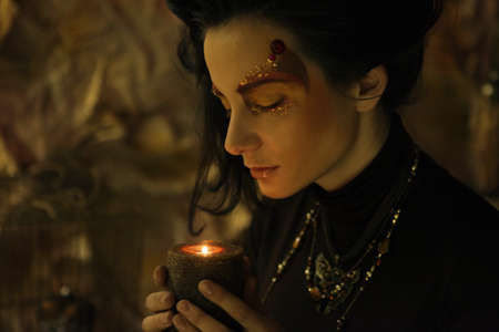 Portrait of beautiful young woman with candleの写真素材