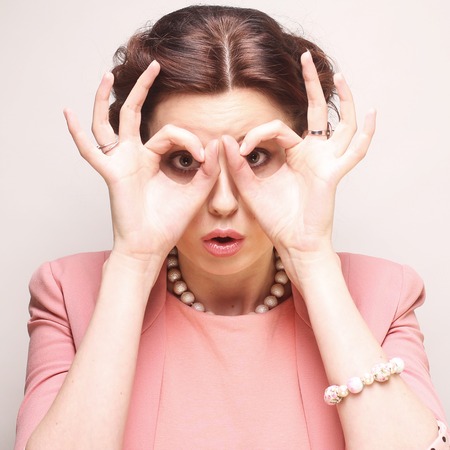 young woman looking for something with wide open eyes and imaginの写真素材