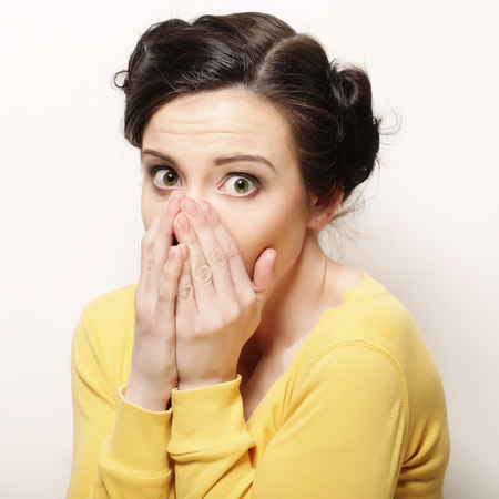 Young woman with hands over mouth.の写真素材