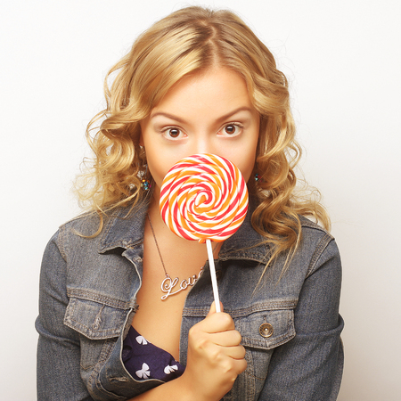 beautiful young woman with big colorful lollipopの写真素材