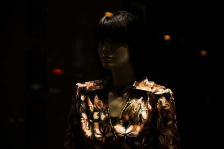 Close-up shot of the store window with a mannequin dressed in a fashionable chemiseの写真素材