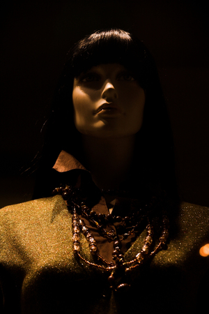 Close-up shot of the store window with a mannequin dressed in a fashionable sweaterの写真素材