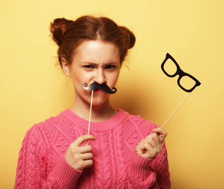 lifestyle and people concept: Happy girl  wearing fake mustachesの写真素材