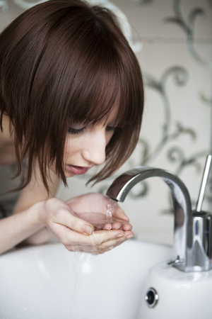 young woman washing her faceの写真素材