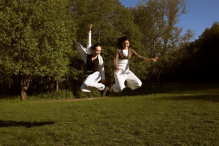 two young girl jump in park