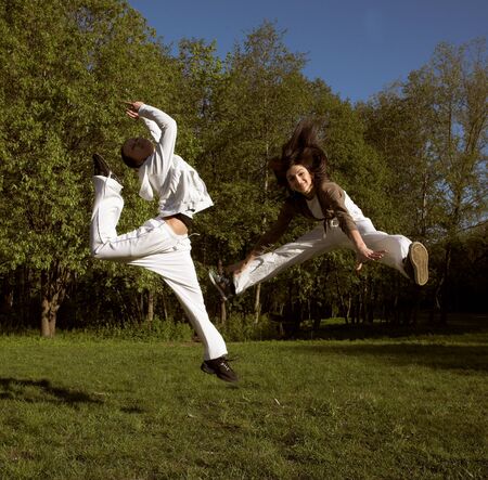 two girl jumping in parkの写真素材