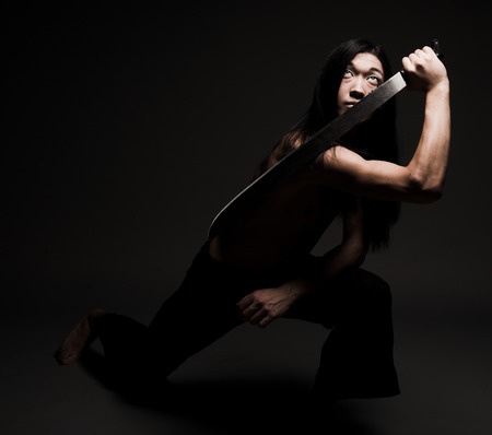 A young asian man in black background.