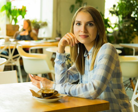 portrait of pretty woman listening music and holding mobile phonの写真素材