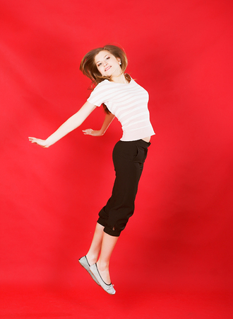 girl jumping of joy over redの写真素材