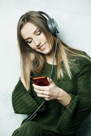 people  and technology concept - happy woman   in headphones listening to music from smartphoneの写真素材
