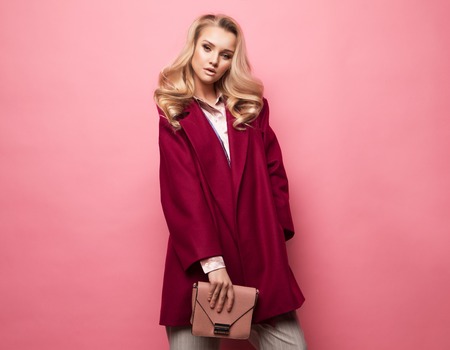 Fashion, people and lifestyle concept: Beautiful woman long blond curly hair wear cashmere coat and holding handbag.の写真素材