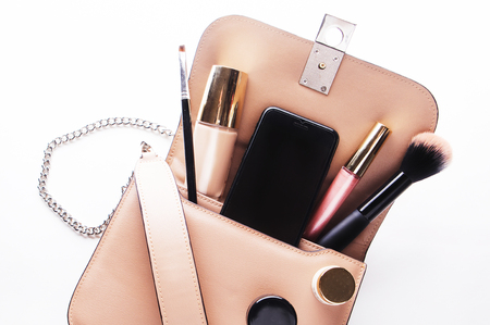 Flat lay of pink leather woman bag open out with cosmetics, acceの写真素材