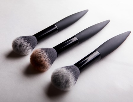 three brushes for powder on white background