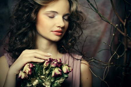 beautiful girl with dry roses in decorationの写真素材