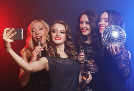 Close-up shot of group of laughing girls having party, take selfの写真素材
