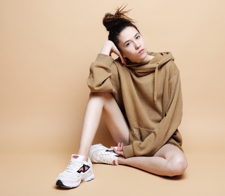 Fashion Model, Fashion, Teenage Girls. Posing over beige backgroundの写真素材