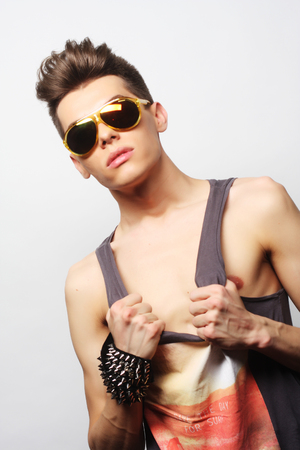 The beautiful young man in sunglasses on a white background.の写真素材