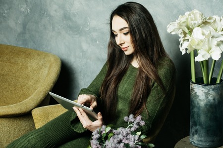 lifestyle, people and tehnology concept: beautiful woman at home working with a tabletの写真素材