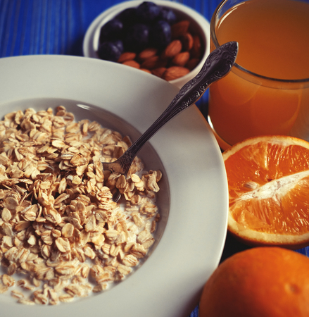 Breakfast with oatmeal and orange juice on blue wooden background. Great for diet.