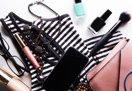 Beauty and fashion concept: Flat lay of pink leather woman bag, cosmetics, accessories and smartphone on white background with copy spaceの写真素材