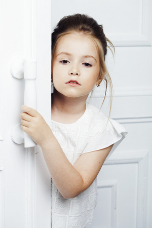 Childrens fashion. Beautiful pensive serious blonde girl in white clothes. Fashion, lifestyle and people concept.の写真素材