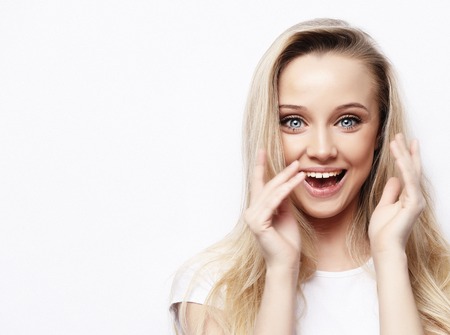 lifestyle and people concept - Beautiful girl surprised and shocked looks on you . Presenting your product. Expressive facial expressions. Studio shoot.の写真素材