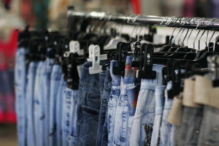 Row of hanged blue jeans in a shopの写真素材
