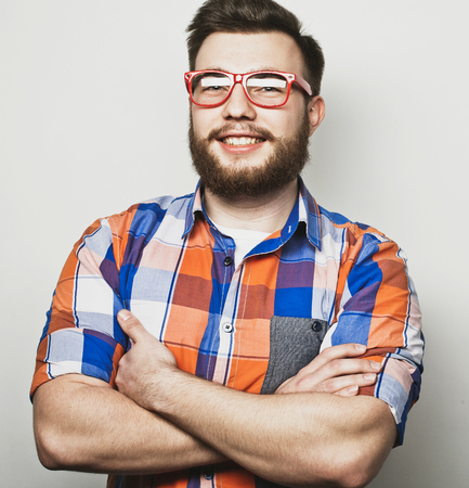 Lifestyle and people concept: Young bearded guy crossing his arms over white backgroundの写真素材