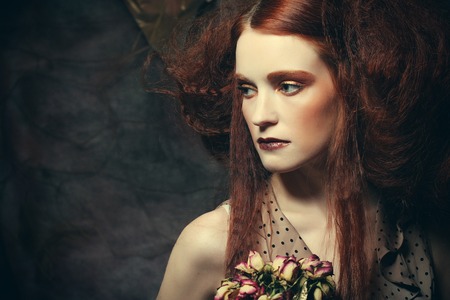 beautiful girl with dry roses in decorationの写真素材