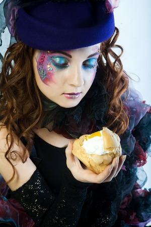 young woman with creative make-up with cake.の写真素材