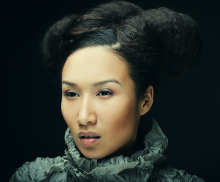 studio portrait of beautiful woman in grey dress with fashion hairstyle. Fashion and beauty concept.