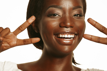 African american woman  smiling looking to the camera showing fingers doing victory signの写真素材