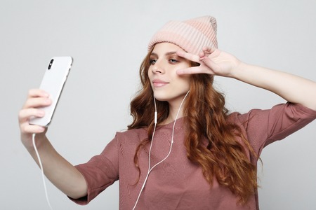 lifestyle and people concept: young woman in headphones with smartphone listening to the music.の写真素材