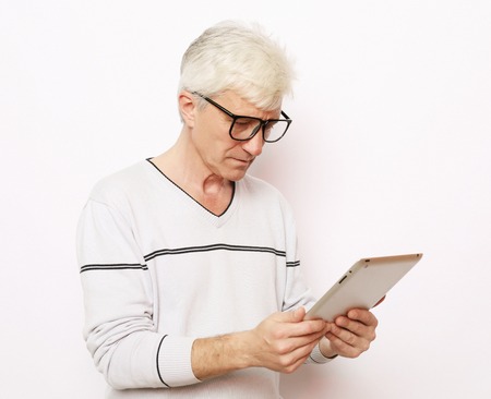 lifestyle, tehnology and people concept: Happy senior man using digital tablet.