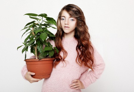 Beauty and fashion concept: Little girl wearing pink outfit and holding flowerの写真素材