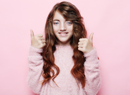 happy people concept - smiling little girl showing peace gestureの写真素材